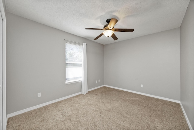 empty room with carpet flooring, a textured ceiling, and ceiling fan