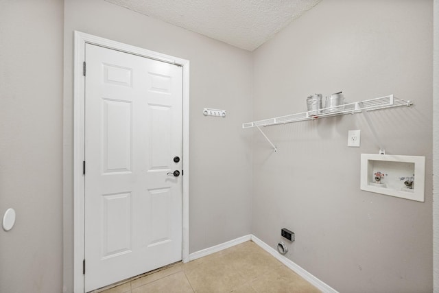 laundry area with hookup for a washing machine, a textured ceiling, light tile patterned floors, and electric dryer hookup