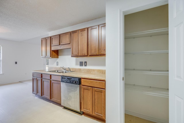 8180 Shooter Ln, Laurel Hill, FL 32567 - kitchen with stainless steel dishwasher, a sink, light countertops, brown cabinets, and a textured ceiling