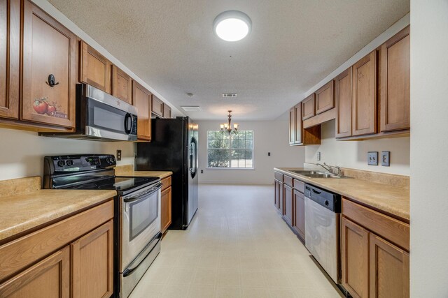 8180 Shooter Ln, Laurel Hill, FL 32567 - kitchen with appliances with stainless steel finishes, a sink, a chandelier, brown cabinets, and light countertops