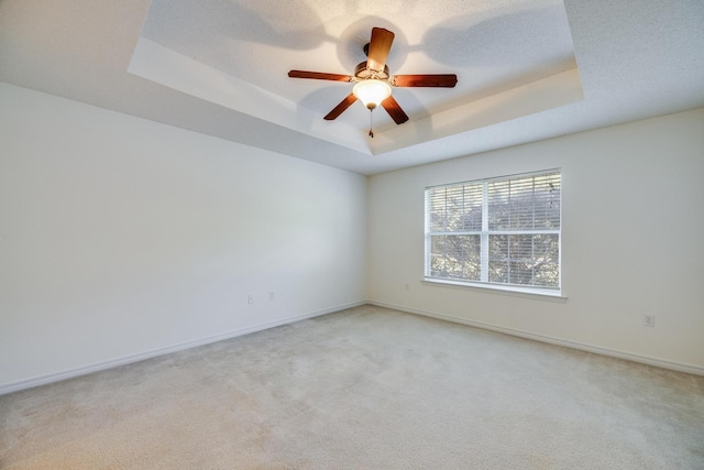 8180 Shooter Ln, Laurel Hill, FL 32567 - spare room with a tray ceiling, light carpet, ceiling fan, and baseboards