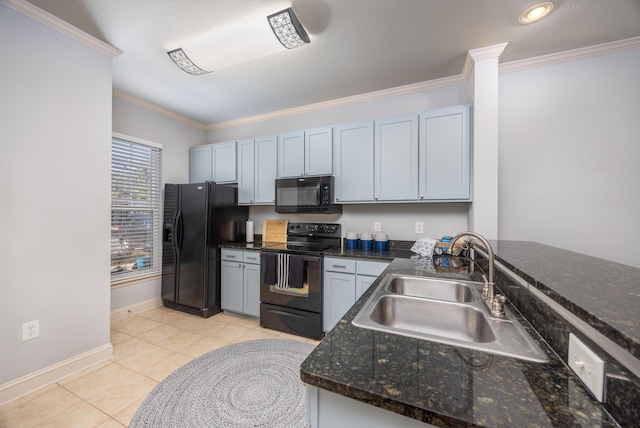 kitchen with dark stone counters, black appliances, sink, ornamental molding, and light tile patterned flooring