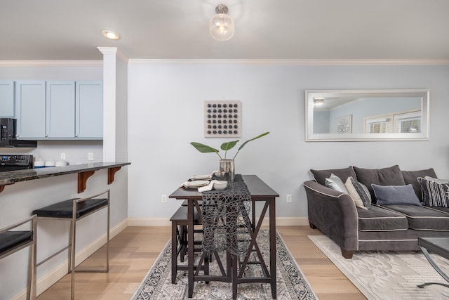 dining area featuring crown molding and light wood-type flooring