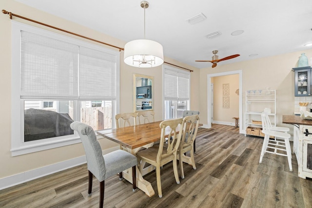 dining area featuring ceiling fan and dark wood-type flooring