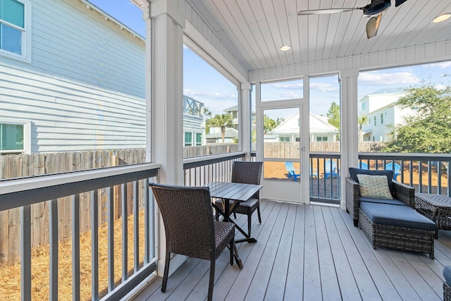 sunroom with ceiling fan and wooden ceiling