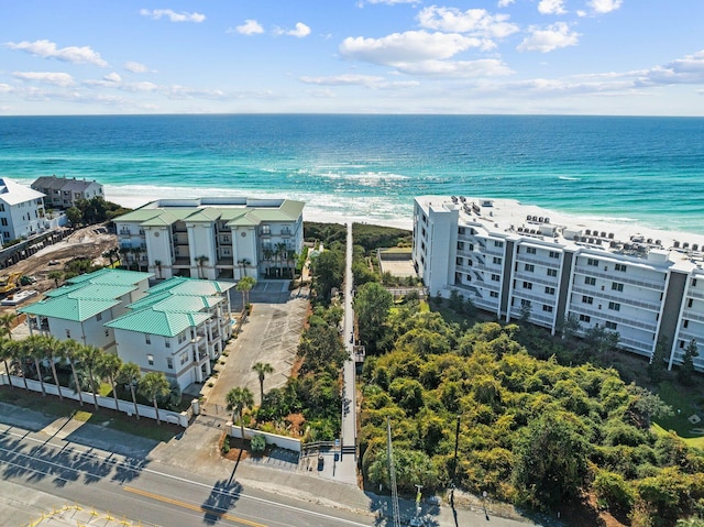 birds eye view of property with a water view and a beach view