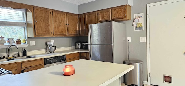 kitchen with a textured ceiling, sink, and appliances with stainless steel finishes