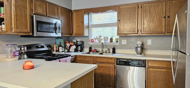 kitchen with kitchen peninsula, appliances with stainless steel finishes, and sink