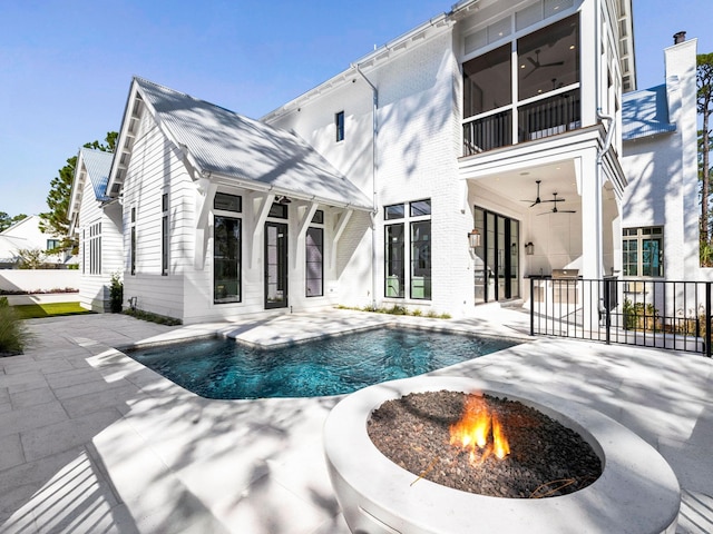 back of property featuring a patio area, ceiling fan, and an outdoor fire pit