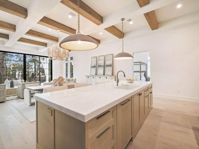 kitchen featuring sink, pendant lighting, light hardwood / wood-style flooring, beamed ceiling, and a large island