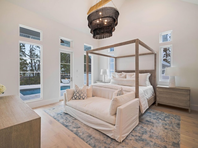 bedroom featuring high vaulted ceiling and wood-type flooring