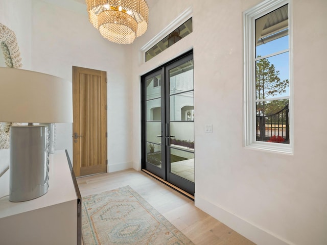 doorway featuring light hardwood / wood-style flooring and a notable chandelier