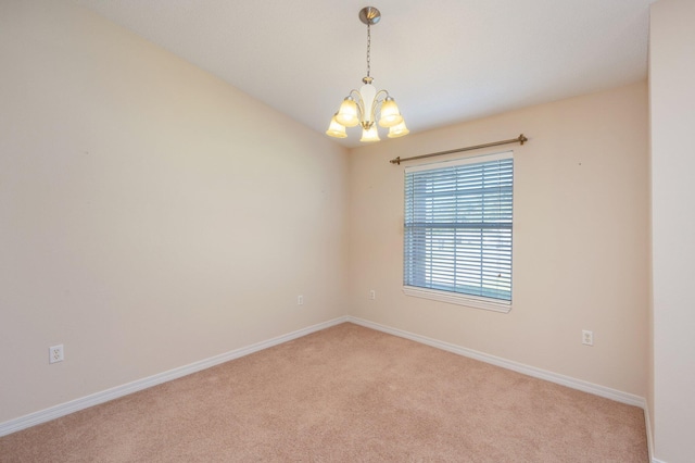 empty room with vaulted ceiling, light colored carpet, and a notable chandelier