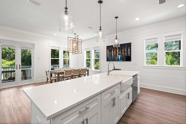 kitchen with white cabinetry, pendant lighting, and a healthy amount of sunlight