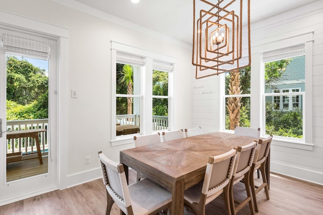 dining area featuring wooden walls, a notable chandelier, and a wealth of natural light