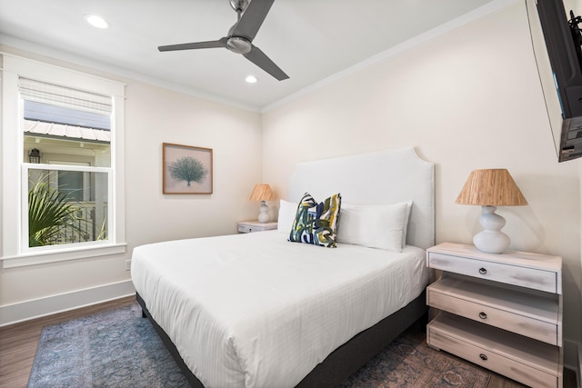 bedroom with dark hardwood / wood-style flooring, ceiling fan, and crown molding