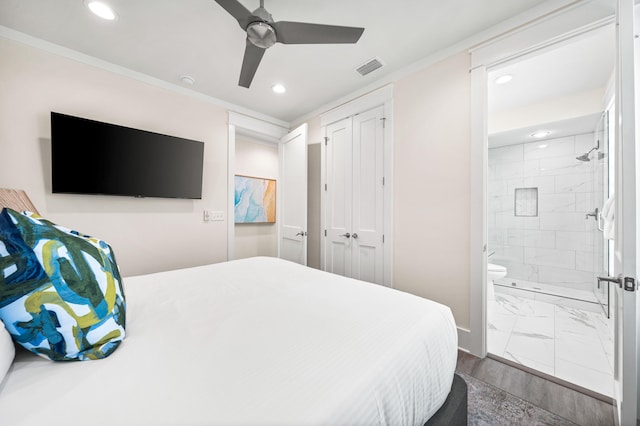 bedroom featuring ensuite bath, ceiling fan, ornamental molding, wood-type flooring, and a closet