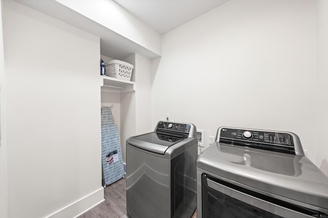 laundry area featuring independent washer and dryer and hardwood / wood-style floors