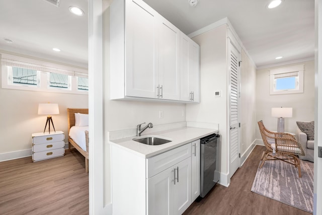 interior space featuring white cabinetry, wood-type flooring, and stainless steel dishwasher