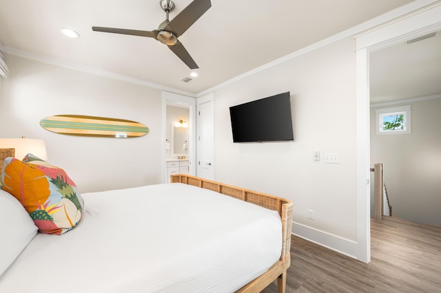 bedroom featuring connected bathroom, hardwood / wood-style flooring, ceiling fan, and crown molding