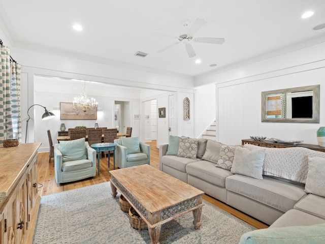 living area with visible vents, light wood-style flooring, ornamental molding, ceiling fan with notable chandelier, and recessed lighting