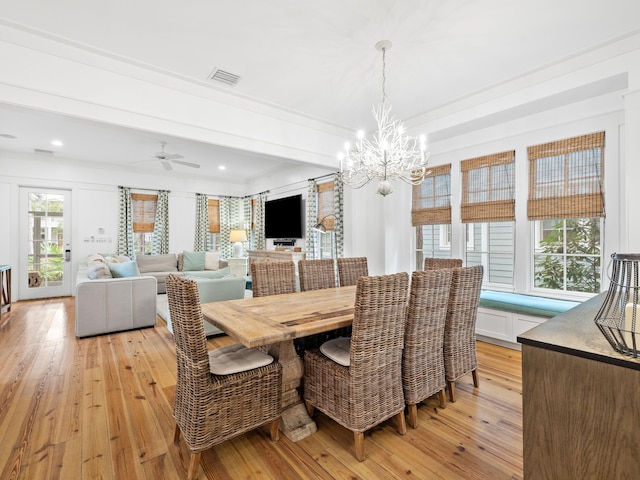 dining room featuring ceiling fan with notable chandelier, light wood-style flooring, visible vents, and crown molding