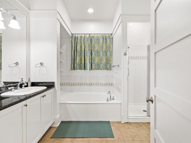 full bath featuring a stall shower, tile patterned floors, a garden tub, and vanity