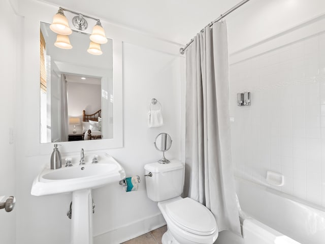 bathroom featuring tile patterned floors, shower / bath combo with shower curtain, toilet, and connected bathroom