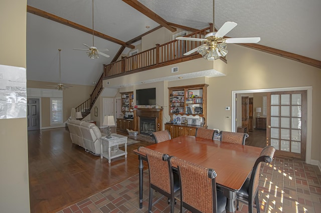 dining room featuring beam ceiling, ceiling fan, high vaulted ceiling, dark hardwood / wood-style floors, and a textured ceiling