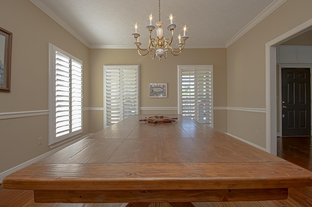 unfurnished dining area with crown molding, hardwood / wood-style floors, a textured ceiling, and an inviting chandelier