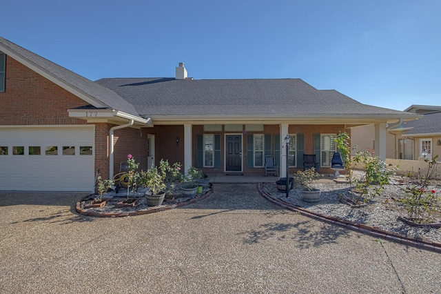 single story home featuring covered porch and a garage