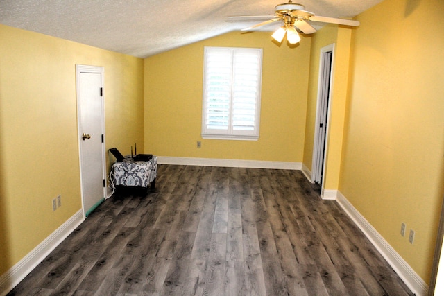 interior space with a textured ceiling, ceiling fan, dark hardwood / wood-style flooring, and vaulted ceiling