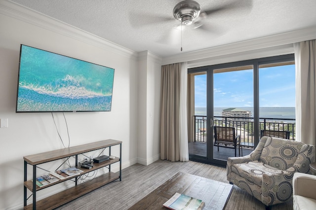 10 Harbor Blvd Unit W528, Destin, FL 32541 - living room with a ceiling fan, crown molding, a water view, a textured ceiling, and wood finished floors