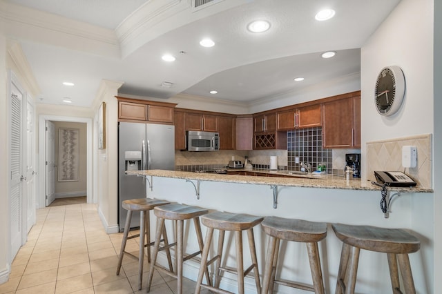 10 Harbor Blvd Unit W528, Destin, FL 32541 - kitchen featuring stainless steel appliances, a peninsula, crown molding, backsplash, and light stone counters