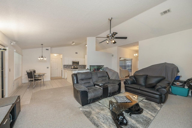 tiled living room with a textured ceiling, ceiling fan with notable chandelier, and lofted ceiling