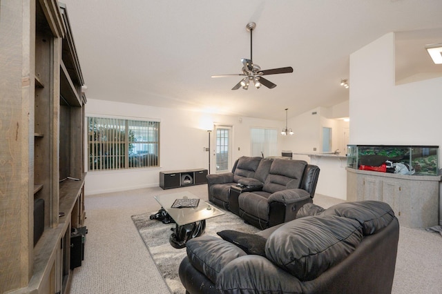 living room with ceiling fan with notable chandelier, lofted ceiling, and light carpet