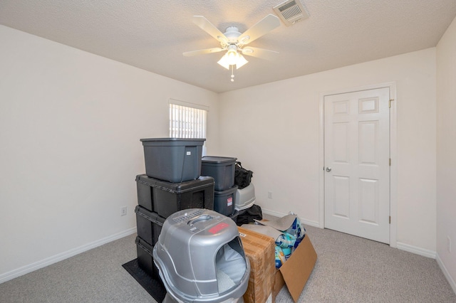 misc room with ceiling fan, light colored carpet, and a textured ceiling