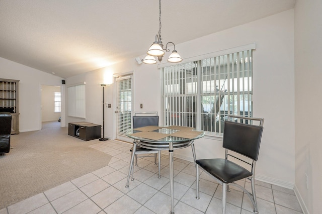 dining area with light tile patterned floors, a wealth of natural light, and lofted ceiling