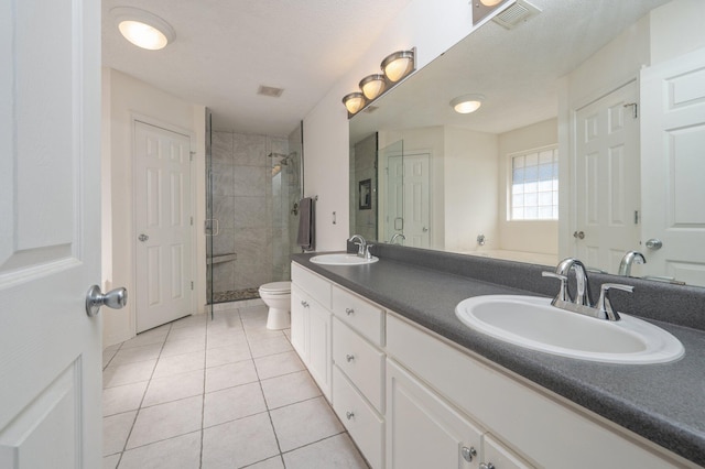 bathroom with walk in shower, tile patterned flooring, a textured ceiling, toilet, and vanity