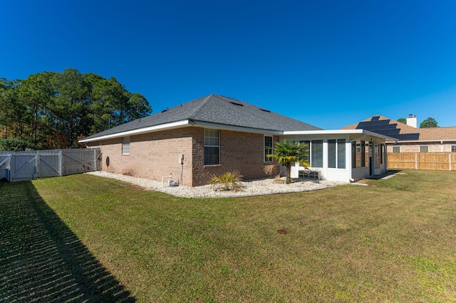 back of property featuring a sunroom and a yard