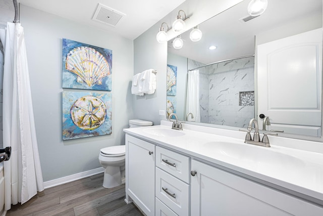 bathroom with a sink, visible vents, toilet, and wood finished floors