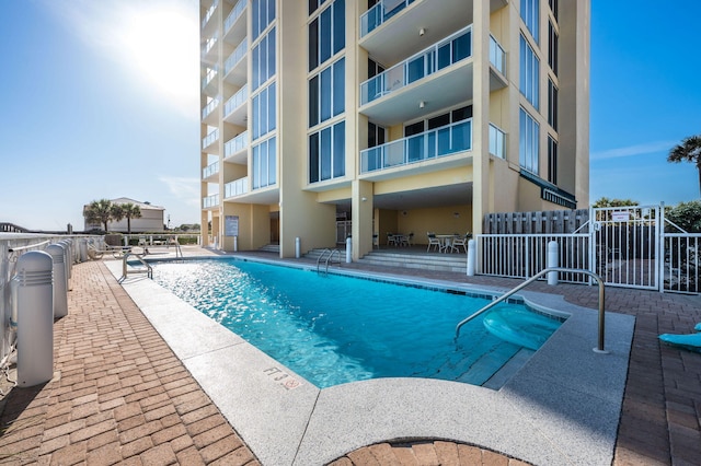 community pool featuring a patio and fence