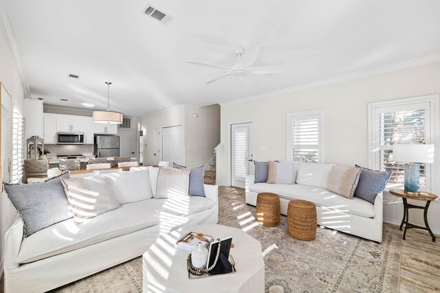 living room featuring ceiling fan, light hardwood / wood-style flooring, and ornamental molding