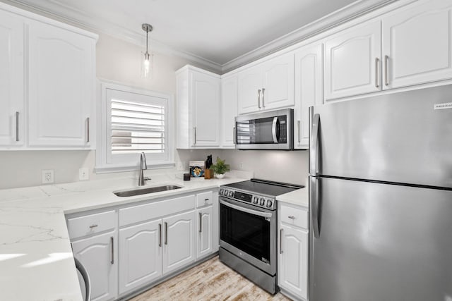 kitchen with white cabinets, sink, stainless steel appliances, and hanging light fixtures