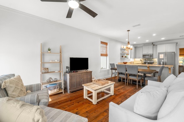 living room featuring dark hardwood / wood-style floors, ceiling fan, sink, and crown molding