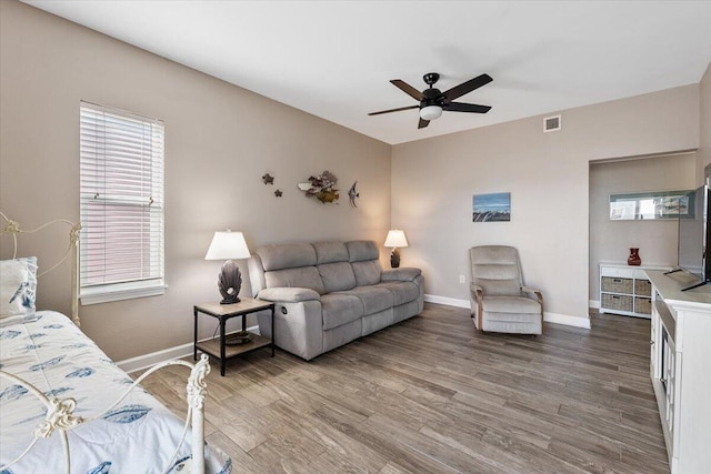 living room featuring ceiling fan, plenty of natural light, and wood-type flooring