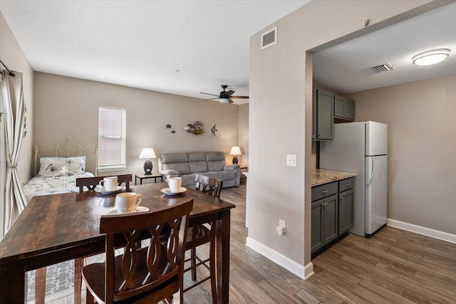 dining room with dark hardwood / wood-style floors and ceiling fan