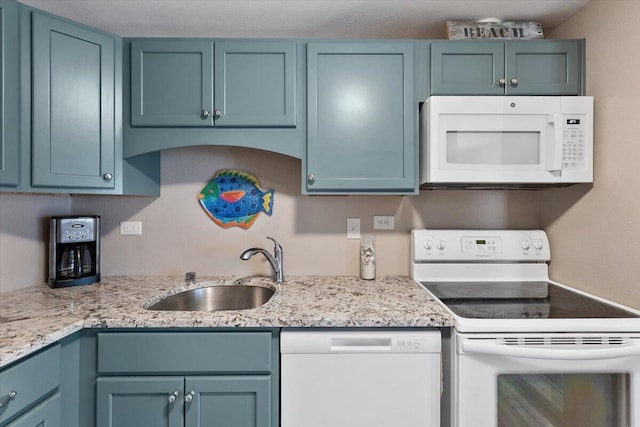 kitchen with blue cabinetry, white appliances, and sink