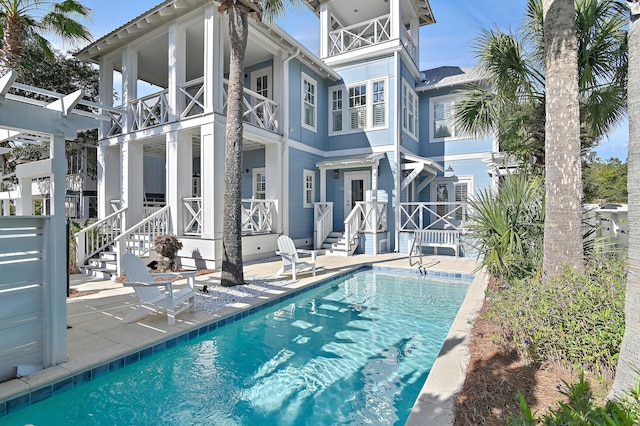 rear view of property with a balcony and a patio