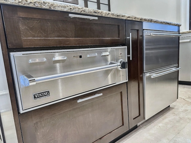 interior details with dark brown cabinetry and light stone countertops